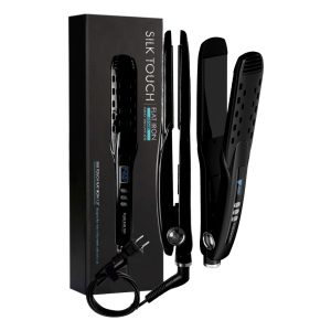 A black Silk Touch Ionic Flat Iron 1.5" with a cord stands upright beside its sleek box, displaying product details in blue and white. The flat iron features a small LCD screen, buttons, and vent holes.