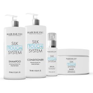 Displayed are four white containers from Hair Bar NYC’s Silk Touch System Duo Bundle: pump bottles of shampoo and conditioner, a small pump bottle of serum, and a wide jar of hair mask, each with minimalist black and blue text.