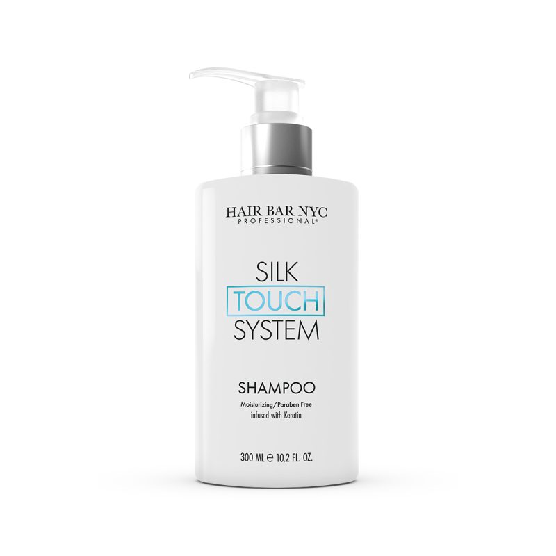A white pump bottle labeled Silk Touch System Shampoo features black and teal text. This moisturizing, paraben-free shampoo is infused with keratin and available in a 300 ml (10.2 fl oz) size.