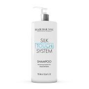 A white 750 ml pump bottle labeled "Silk Touch System Shampoo" with "TOUCH" in blue, featuring “Moisturizing / Paraben Free infused with keratin.”.