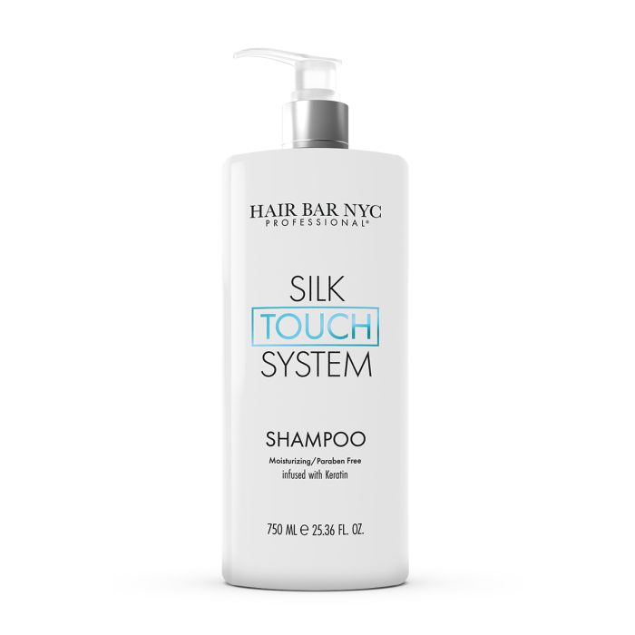 A white 750 ml pump bottle labeled "Silk Touch System Shampoo" with "TOUCH" in blue, featuring “Moisturizing / Paraben Free infused with keratin.”.