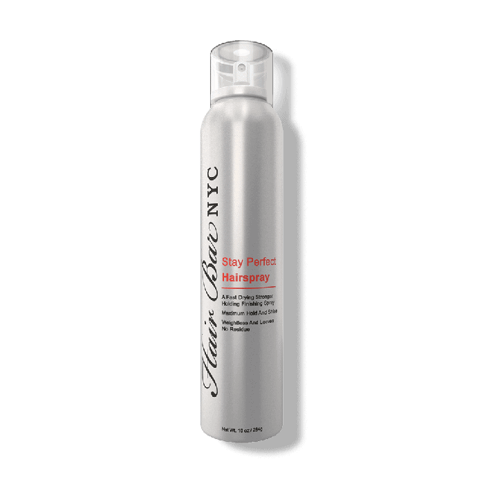 A sleek silver aerosol can of Stay Perfect hairspray stands upright, featuring black and red text for branding and product details. The design is modern with a translucent cap.