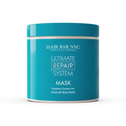 A blue plastic jar labeled "Ultimate System Repair Mask" with a matching blue lid, photographed on a white background. This weightless, paraben-free mask is infused with marine keratin for hair repair.