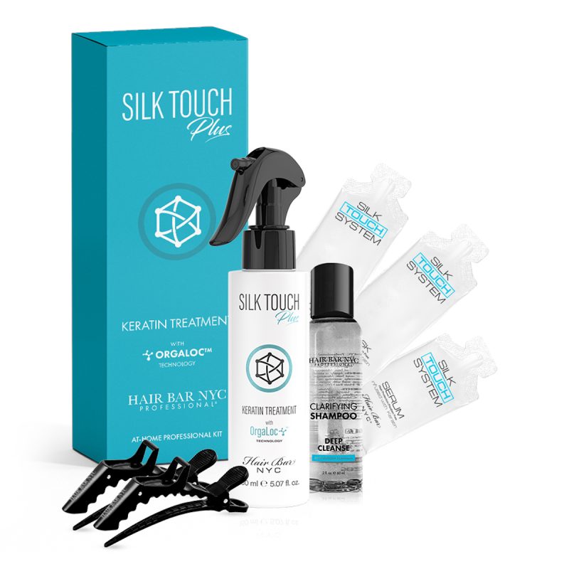 The Vegan Keratin Home Kit features a turquoise Silk Touch Plus box behind a spray bottle, cleanser, three serum vials, and four black hair clips, all professionally arranged for convenient at-home hair care.